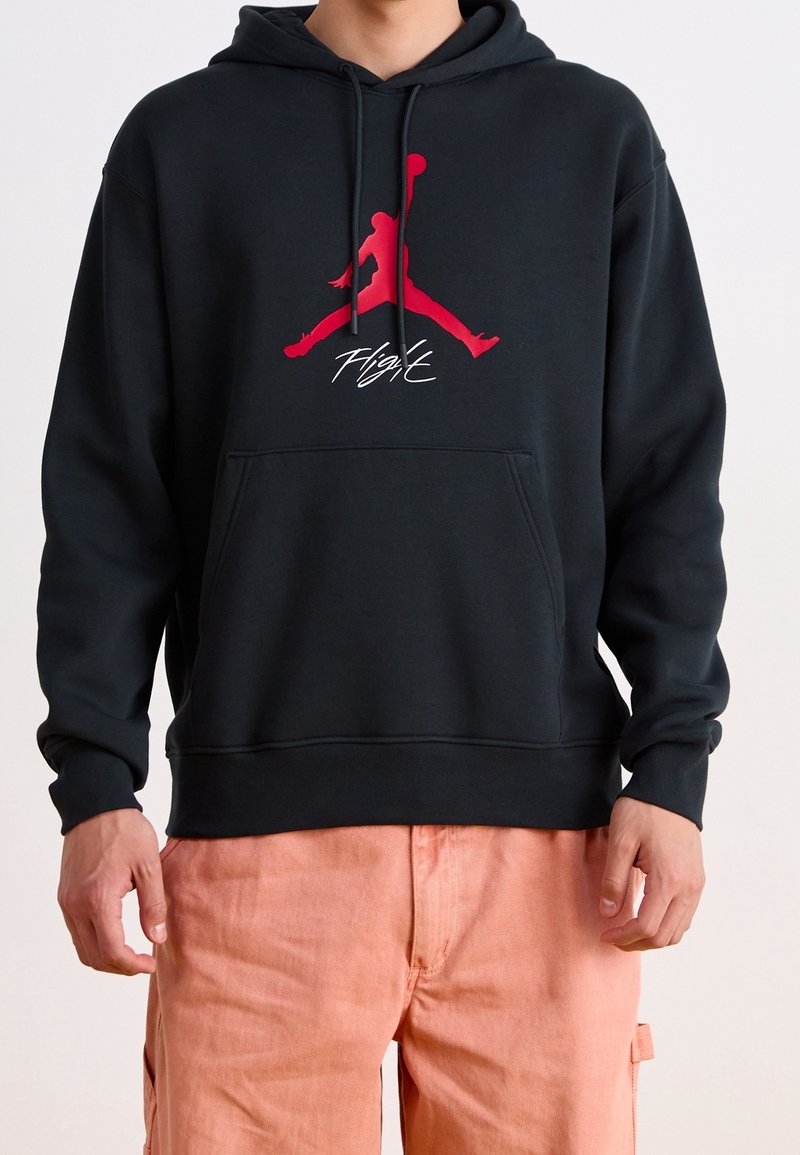 Sudadera negra con bolsillo canguro en el frente, que presenta un gran logo rojo de Jordan y el texto "FLIGHT" debajo. Material de mezcla de algodón, corte informal.