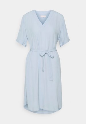 Hellblaues, knielanges Kleid mit V-Ausschnitt, kurzen Ärmeln und einem Stoffgürtel, der in der Taille auf einem einfarbigen Hintergrund gebunden ist.