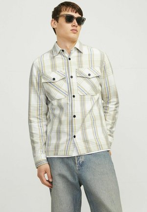 Camisa de cuadros hecha de algodón suave, con bolsillos oversized en el pecho, botonadura frontal y una mezcla de colores verde, azul y blanco.