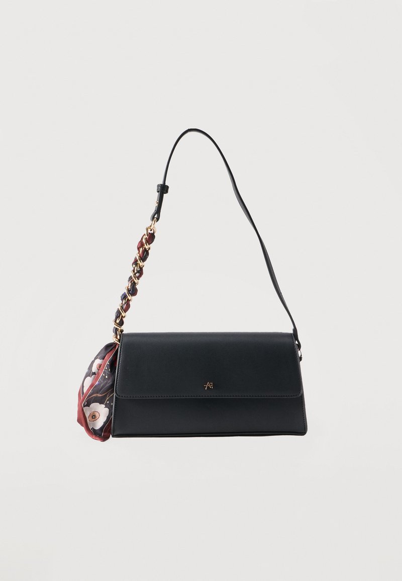 Sac d'épaule rectangulaire noir avec une sangle tressée et un foulard à motif floral attaché sur fond blanc.