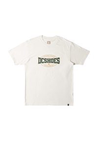 White cotton t-shirt with short sleeves, featuring a green and orange logo design in the center that reads "DCSHOES Established 1994."