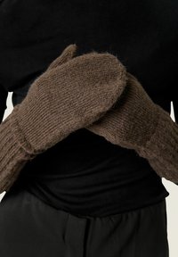 Moufles en tricot marron avec une texture côtelée et un tissu épais, présentant une forme arrondie et des coutures visibles au niveau du poignet.