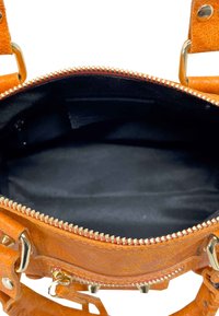 Brązowa torba zamszowa z złotymi akcentami, zamknięcie na zamek błyskawiczny oraz przestronne czarne wnętrze. Posiada teksturowany zewnętrzny materiał oraz mocne uchwyty.