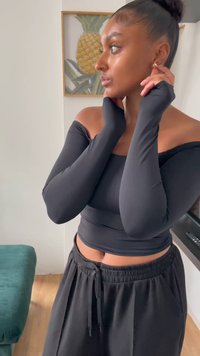 Fekete, hosszú ujjas, vállat kihangsúlyozó felső fekete, magas derekú sportnadrággal párosítva. Simogató, rugalmas anyag; testhezálló fazon; minimális részletek.