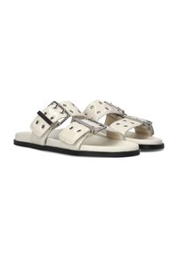 Witte leren sandalen met twee brede banden voorzien van zilveren gespen en oogjes, flatte zwarte zolen en een minimalistisch ontwerp.