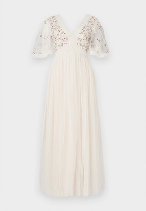 Μακρύ φόρεμα σε κρέμ απόχρωση, με κοντά μανίκια φουσκωτά, ντεκολτέ σε σχήμα V, κεντητά λουλουδάτα σχέδια και υφασμάτινη υφή με διακριτικές κουκκίδες.