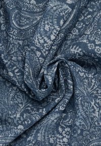 Tessuto blu scuro con un motivo paisley in tonalità più chiare, caratterizzato da intricati disegni floreali e fogliari. Texture morbida, drappeggiato e stropicciato.