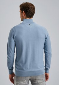 Lichtblauwe, gestructureerde trui met lange mouwen en een hoge kraag, met een klein logo op de achterkant en ribgebreide manchetten en zoom.