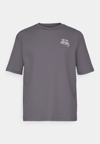 Γκρι κοντομάνικο T-shirt φτιαγμένο από υφασμένο ύφασμα, με μικρή λευκή γραφική σχεδίαση στο στήθος. Κλασικό στρογγυλό ντεκολτέ, χαλαρή εφαρμογή.