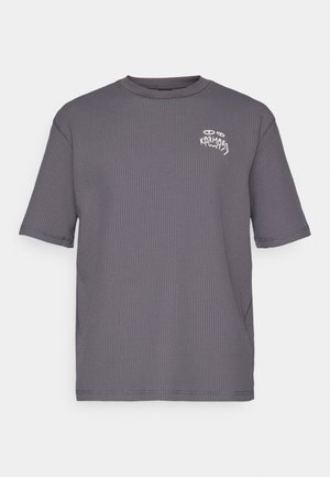 Pilkas trumpas rankovės marškinėlius, pagamintas iš tekstūrinio audinio, su maža balta grafika ant krūtinės. Klasikinis apvalus kaklas, laisvas kirpimas.