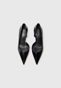 Ein Paar schwarze Lackleder-Ballerinas mit spitzem Zehenbereich und Ausschnittdetails, innen mit Michael Kors-Label.
