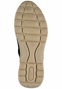 Podešev tenisky z lehkého béžového gumového materiálu s texturovaným vzorem a kruhovými úchyty. Obsahuje označení velikosti.