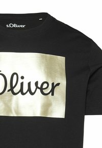 Schwarzes Baumwoll-T-Shirt mit einem rechteckigen Grafikdruck in Goldfolie, der den Text "s.Oliver" in einer fetten, geschwungenen Schriftart zeigt. Rundhals.