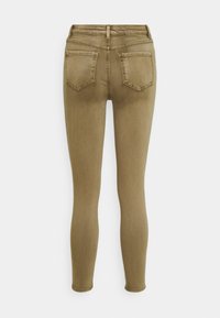 Jeans ajustados en tela de mezcla de algodón verde oliva, con una cintura de altura media, dos bolsillos traseros y una textura suave sin adornos visibles.