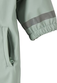 Light green waterproof jacket with elastic cuffs, a zippered pocket, and a reflective gray stripe across the arm. Smooth texture.