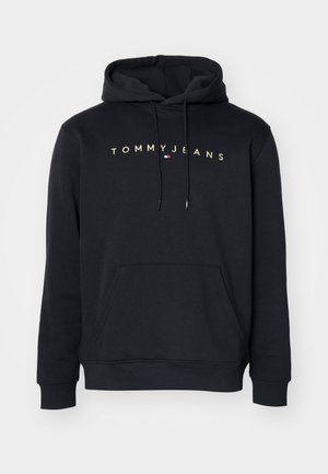 Czarna bluza z kapturem z kieszenią kangurkową z przodu, kapturem z troczkami oraz logo "TOMMY JEANS" w beżowych literach z małą flagą pod spodem.
