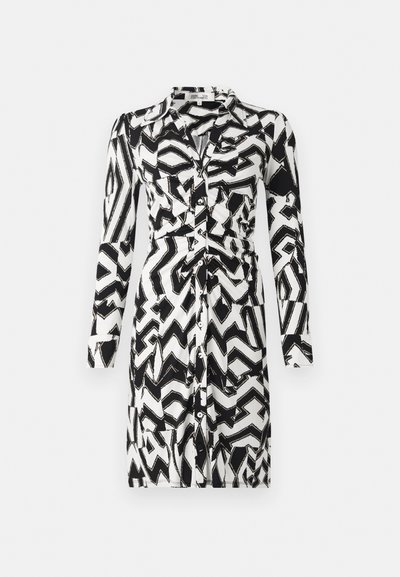 Rochie cu model alb-negru, cu mâneci lungi, închidere cu nasturi, guler și detaliu cu talie strânsă. Design abstract în zigzag pe toată suprafața.