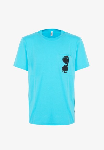 Maglietta di cotone azzurra chiara con scollo rotondo e maniche corte. Presenta una grafica di occhiali da sole neri nella zona del taschino sinistro.