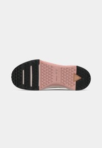 Semelle de chaussure avec des sections en caoutchouc roses et noires, motif de bande de roulement triangulaire et deux rainures horizontales sur la moitié avant.