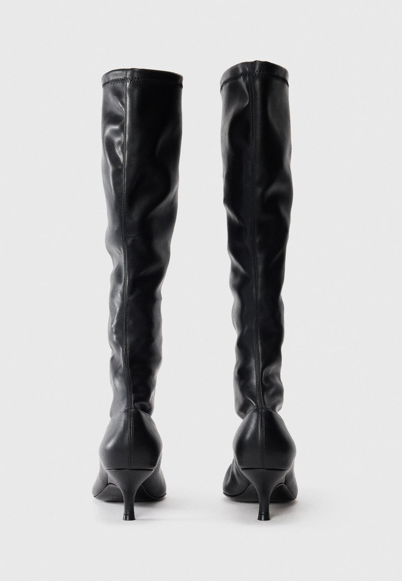 Schwarze, über das Knie gehende Lederstiefel mit glatter Textur, tapered hohen Absätzen und tailliertem Design, mit Nähten an der Rückseite.