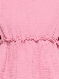 Tissu rose texturé avec une ceinture élastique froncée créant un effet froncé au centre.