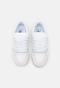 Zapatillas blancas con una parte superior de cuero suave, puntera texturizada, cordones blancos planos y acentos en azul claro en los laterales y en la plantilla.