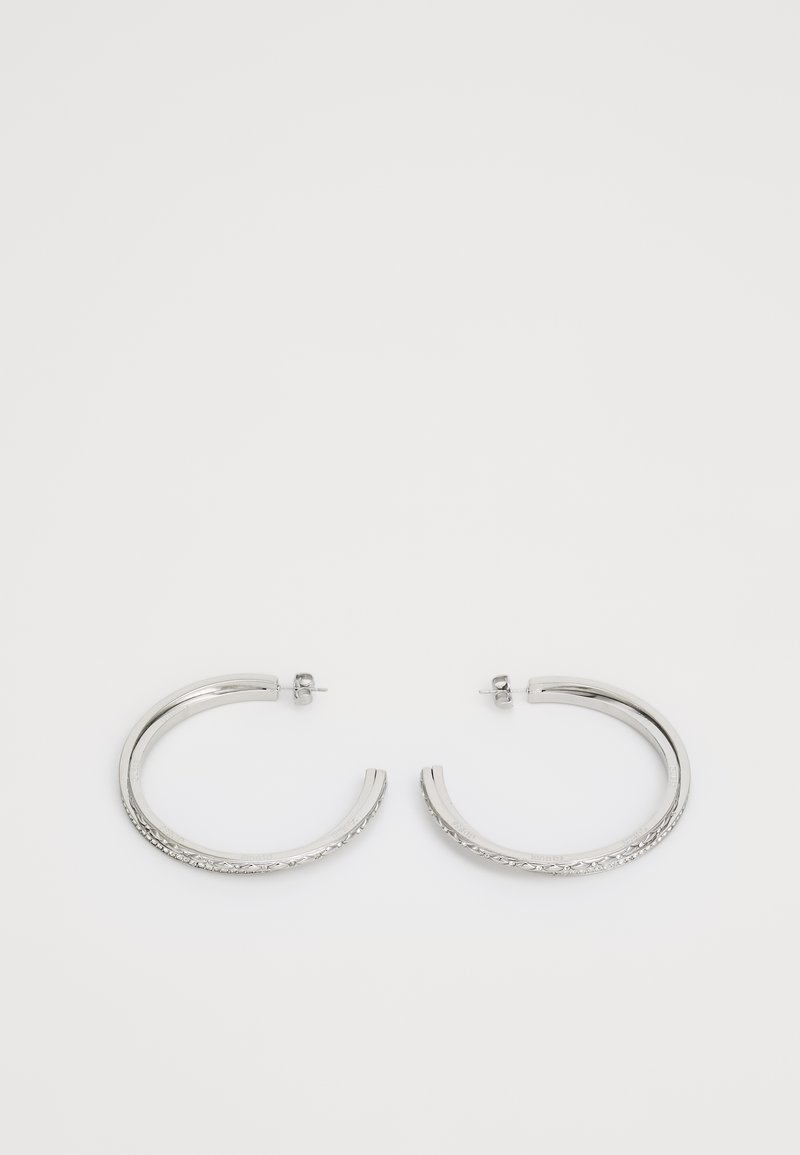 Sølv hoop øredobber med et teksturert design langs den ene kanten, med en glatt overflate og en post-back lukking.