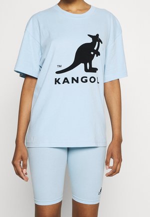 Ljusblå bomullströja med kort ärm och en svart känguru-logotyp, tillsammans med matchande ljusblå cykelshorts.