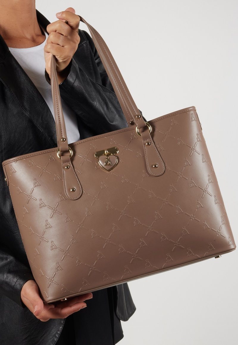 Brun, struktureret, syntetisk tote taske med prægede mønstre, guldaccenter og dobbelt håndtag. Har en hjerteformet låsebeslag.