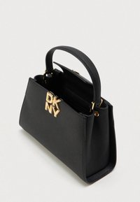 Μαύρη δομημένη τσάντα χειρός με επάνω χερούλι και χρυσό κούμπωμα λογότυπου DKNY, εμφανίζεται ανοιχτή σε απλό ανοιχτό φόντο.