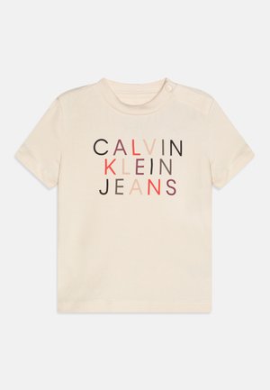 Κοντομάνικη μπλούζα από βαμβάκι σε κρέμα, με πολύχρωμο γραφικό τύπωμα του "CALVIN KLEIN JEANS" σε διάφορα βάρη και χρώματα.