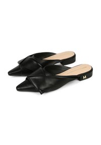 Svarta lädermules med spetsig tå och vridet frontdesign. Har en låg blockklack med en gyllene "M"-accent. Slät textur.