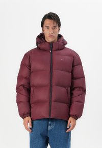 Chaqueta de abrigo burdeos con cremallera frontal, capucha ajustable y puños elásticos. Presenta secciones acolchadas para aislamiento y un diseño casual.