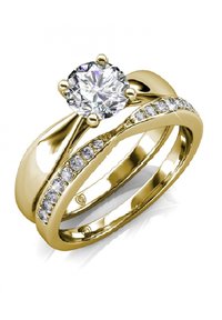 Set di anelli nuziali in oro con una grande pietra centrale a forma di diamante rotondo e piccole pietre di accento lungo una fascia, finitura liscia e lucida.