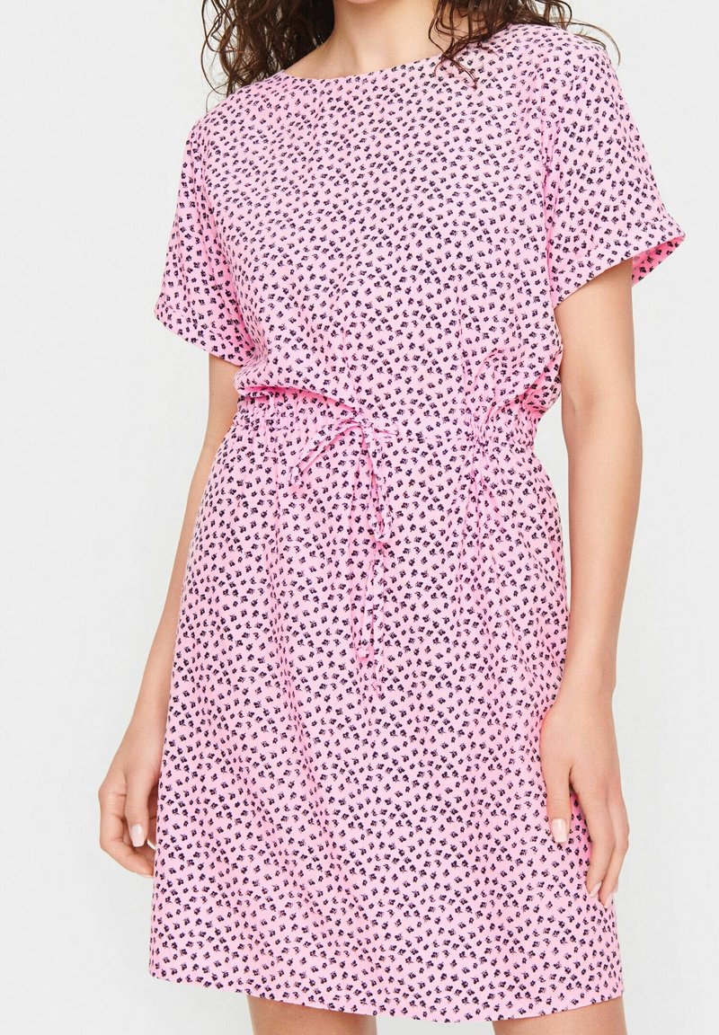 Rosa kortärmad klänning med knyt-midja, tillverkad av lättviktsmaterial med små svarta hjärtan i tryck.