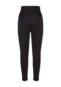 Schwarze Sweatpants mit einem strukturierten, elastischen Bund, enganliegendem Schnitt und schmal zulaufenden Beinen, aus einem weichen Stoff. Keine sichtbaren Taschen.