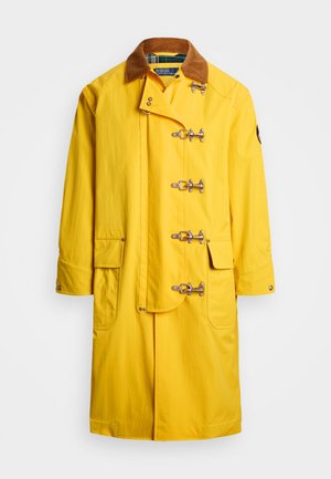 Geltonas vandeniui atsparus paltas su ruduo veliūro apykakle, užsegimu su kabliukais ir dviem šoninėmis kišenėmis. Lygus paviršius ir vidutinio ilgio dizainas.