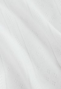 Weißes Strickgewebe mit einem strukturierten Muster aus vertikalen Streifen und kleinen Rauten. Weiche Textur und leichter Eindruck.