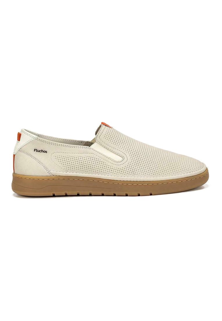 Zapatos slip-on con una parte superior de piel perforada beige, acento naranja en contraste y una suela de goma marrón claro, presentando una textura suave y un diseño minimalista.
