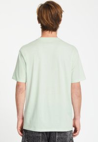 Lys mintgrøn bomulds t-shirt med rund hals og korte ærmer, der har en glat tekstur og en afslappet pasform. Ingen synlige grafik eller mønstre.