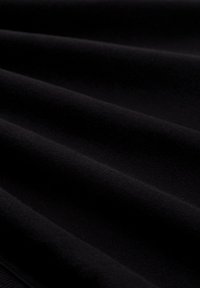 Schwarzer Stoff mit einer glatten Textur, der sanfte Falten und Knitter aufweist. Das Material wirkt leicht und leicht dehnbar.