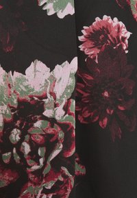 Bloemstof met een zwarte achtergrond; bevat grote bloemen in rood, roze en groen. Textuur oppervlak met ingewikkelde patronen van bloemblaadjes en bladeren.