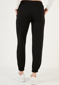 LELA Pantaloni de trening - black