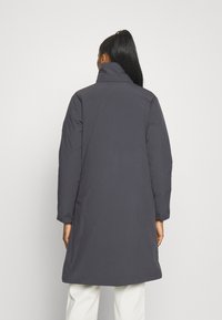 Donkergrijze pufferjas met een hoge kraag, lange mouwen en een ontspannen pasvorm, voorzien van een gladde textuur en een middellange ontwerpen.
