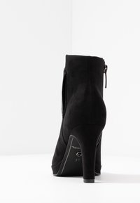 Musta korkokenkä nilkkuri, jossa on sileä mokkanahka pinta, sivuvetoketjukiinnitys ja kaventuva korko. Kokoetiketti 37 näkyvissä pohjassa.