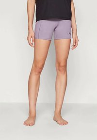 Lila sportos rövidnadrág sima, rugalmas anyagból. Diszkrét logóval, testhezálló fazonnal és combközép hosszúsággal rendelkezik.