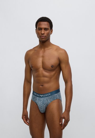 Pánské slipy Emporio Armani s modrobílým vzorem, s páskem se značkou a přiléhavým střihem.