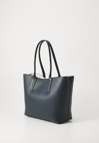Sac fourre-tout en cuir texturé bleu marine, de forme rectangulaire, avec des poignées doubles et une ouverture en haut. Présente une doublure intérieure contrastante.