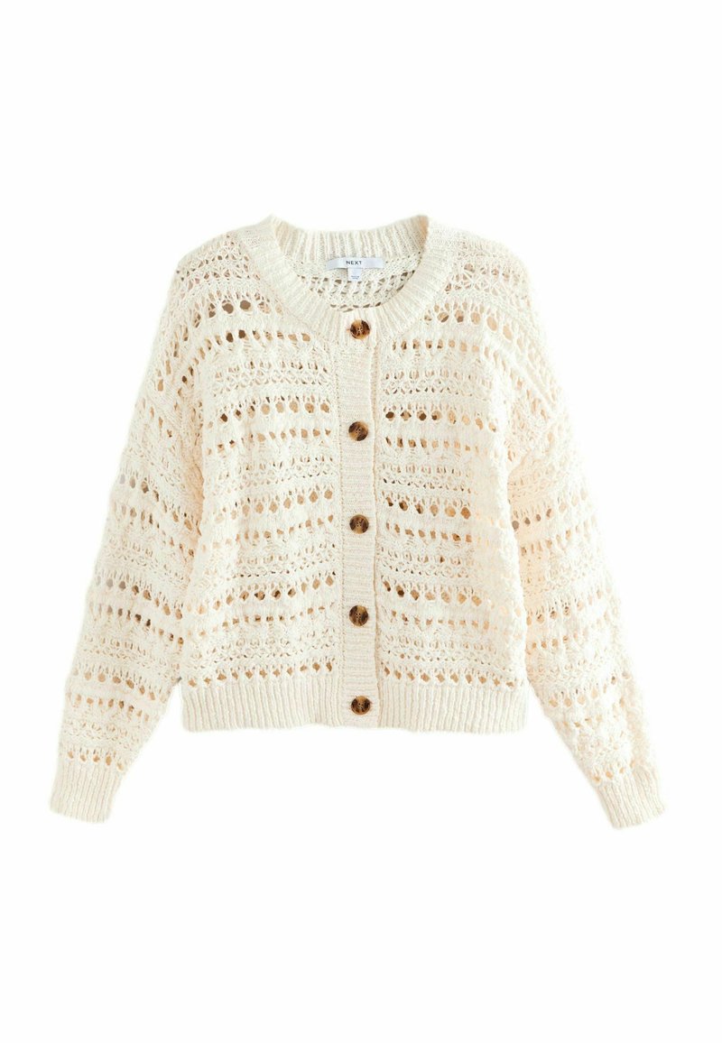 Cardigan tricoté en crème avec un motif ajouré, sept boutons sur le devant, larges poignets et un col rond. Coupe régulière avec un tissu texturé.