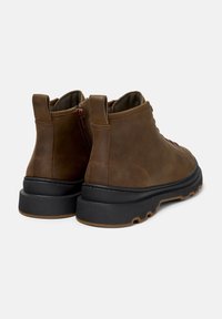 Brown leather ankle boots with a smooth finish, round toe, black rubber outsole, and rear zipper closure for easy access.
